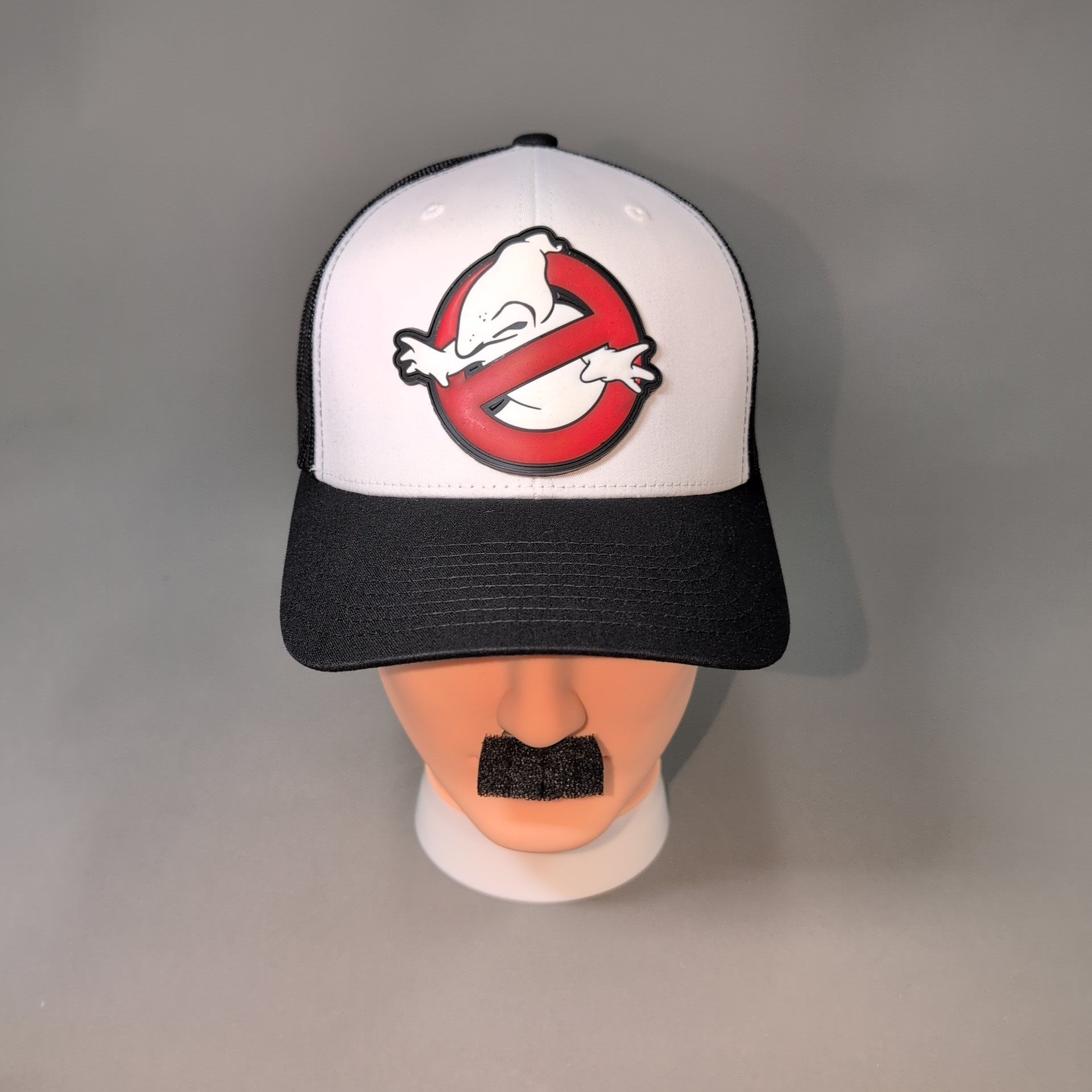 Nosebusters • PVC Patch • White / Black Curved Bill Trucker Cap